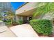 Building exterior featuring a covered entrance with well-maintained landscaping and lush greenery at 4381 Sandner Dr, Sarasota, FL 34243