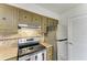 Kitchen featuring stainless steel oven, upper cabinets, and stainless steel refrigerator at 4381 Sandner Dr, Sarasota, FL 34243