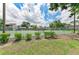 Outdoor tennis court with a chain-link fence and blue skies in a lush, green community setting at 4381 Sandner Dr, Sarasota, FL 34243