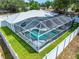 A high-angle shot of a metal roof house with a fully screened-in pool and a surrounding yard at 4425 Parnell Dr, Sarasota, FL 34232