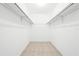 Walk-in closet with neutral paint and tile flooring with shelving for storage at 4425 Parnell Dr, Sarasota, FL 34232