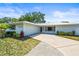 Beautifully landscaped single-story home with a new metal roof, lush landscaping, and an attached two-car garage at 4425 Parnell Dr, Sarasota, FL 34232