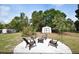 Backyard with outdoor chairs around fire pit, storage shed, and a lush green space, ready for entertainment at 4506 20Th W St, Bradenton, FL 34207