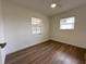 This bright bedroom has wood floors, white walls, and two windows with blinds at 4506 20Th W St, Bradenton, FL 34207