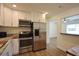 Modern kitchen features stainless steel appliances, white cabinets, and wood-look flooring with open access to another room at 4506 20Th W St, Bradenton, FL 34207