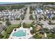Aerial view features a community pool, playground, and scenic water view nestled among neatly arranged homes and tree-lined streets at 4811 Woodbrook Dr, Sarasota, FL 34243
