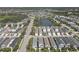 Aerial view of a well-planned community with neatly aligned homes, lush landscaping, and a serene lake at 4811 Woodbrook Dr, Sarasota, FL 34243