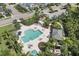 Aerial view captures a community pool and recreational area featuring lounge chairs, covered seating, and meticulously maintained landscaping at 4811 Woodbrook Dr, Sarasota, FL 34243