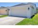A bright, two-car garage with carriage lamps and a concrete driveway at 4811 Woodbrook Dr, Sarasota, FL 34243