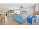 Bright open-plan living room with tile flooring, ceiling fan, and comfortable furnishings in a beach-themed color palette at 4811 Woodbrook Dr, Sarasota, FL 34243