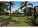 Expansive backyard with mature trees, lush lawn, and tranquil water view creates a serene outdoor retreat at 5036 Brickell Park Cv, Bradenton, FL 34211