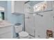 Bright bathroom featuring a glass shower, tiled walls, window, and a toilet with storage shelves above at 5036 Brickell Park Cv, Bradenton, FL 34211