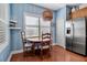 Dining nook with a round table, shuttered windows and stainless steel refrigerator at 5036 Brickell Park Cv, Bradenton, FL 34211