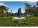 Boy and Dog statue surrounded by flower garden at entrance to dog park at 5036 Brickell Park Cv, Bradenton, FL 34211