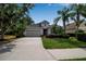 Charming single-Gathering home featuring a well-manicured lawn, mature palm trees, and a two-car garage at 5036 Brickell Park Cv, Bradenton, FL 34211