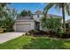 Charming single-Gathering home featuring a well-manicured lawn, mature palm trees, and a two-car garage at 5036 Brickell Park Cv, Bradenton, FL 34211