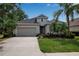 Charming single-Gathering home featuring a well-manicured lawn, mature palm trees, and a two-car garage at 5036 Brickell Park Cv, Bradenton, FL 34211