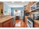 Cozy kitchen with wooden cabinets, stainless fridge, and open dining area with hardwood floors at 5036 Brickell Park Cv, Bradenton, FL 34211