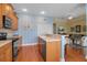 Bright kitchen with wooden cabinets, stainless oven, and eat-in bar open to living area at 5036 Brickell Park Cv, Bradenton, FL 34211