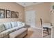 Neutral-toned living room featuring a striped couch, ottoman, and framed wall art at 5036 Brickell Park Cv, Bradenton, FL 34211