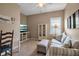 Cozy living room featuring a striped sofa, TV, glass cabinet, and a desk with a comfortable chair at 5036 Brickell Park Cv, Bradenton, FL 34211