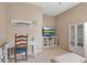 Cozy living room featuring a TV, glass cabinet, desk with chair, ottoman, and light walls at 5036 Brickell Park Cv, Bradenton, FL 34211
