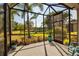 Screened-in patio with seating, overlooking a lake and landscaped backyard at 5036 Brickell Park Cv, Bradenton, FL 34211
