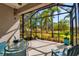 A screened-in patio with glass table and outdoor seating, perfect for relaxation at 5036 Brickell Park Cv, Bradenton, FL 34211