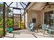 Screened-in patio with a ceiling fan and view of the yard and neighboring buildings at 5036 Brickell Park Cv, Bradenton, FL 34211