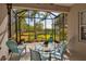 Screened-in patio with a glass table and four chairs, overlooking a garden and pond at 5036 Brickell Park Cv, Bradenton, FL 34211