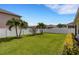Lush green backyard with palm trees, manicured shrubs, privacy fence, and neighbor's beige homes at 5111 11Th E St, Bradenton, FL 34203