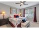 Comfortable bedroom with a ceiling fan, a colorful quilt, and elegant lamps on the nightstands at 5111 11Th E St, Bradenton, FL 34203