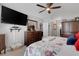 A cozy bedroom featuring a mounted flat-screen TV, ceiling fan, and wooden furniture at 5111 11Th E St, Bradenton, FL 34203
