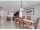 Open dining area with an elegant light fixture leading to an open kitchen, and large windows at 5111 11Th E St, Bradenton, FL 34203