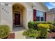 Charming front entrance with inviting red door, burgundy shutters and vibrant, colorful landscaping at 5111 11Th E St, Bradenton, FL 34203