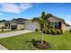 Exterior shot of a home with well-manicured lawn, garden and flower bed with beige siding at 5111 11Th E St, Bradenton, FL 34203