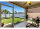 A screened porch features an outdoor view of a green lawn and fenced yard with a table and chair at 5111 11Th E St, Bradenton, FL 34203