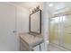 A well-lit bathroom featuring a vanity with a framed mirror and a glass-enclosed shower at 5200 Gulf Dr # 408, Holmes Beach, FL 34217