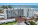 Exterior view of a beachfront condo building with a well-maintained facade and ample parking at 5200 Gulf Dr # 408, Holmes Beach, FL 34217