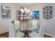 Dining area featuring modern chandelier, glass table and view of the kitchen at 523 Spring Lakes Blvd, Bradenton, FL 34210