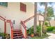 Exterior stairs leading to condo entrance, surrounded by lush landscaping at 523 Spring Lakes Blvd, Bradenton, FL 34210