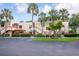 Condo complex boasts lush landscaping with mature palm trees and a well-maintained facade at 523 Spring Lakes Blvd, Bradenton, FL 34210