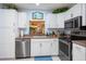 Well-lit kitchen with stainless steel appliances, white cabinetry and view to outdoor living area at 523 Spring Lakes Blvd, Bradenton, FL 34210