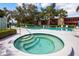 Outdoor pool area with lounge chairs, a hot tub, and greenery surrounding the pool at 523 Spring Lakes Blvd, Bradenton, FL 34210
