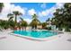 Inviting community pool surrounded by lush landscaping and ample lounging space with seating and umbrellas at 523 Spring Lakes Blvd, Bradenton, FL 34210