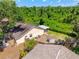 An aerial view of the backyard, which features a large grassy area, screen patio, and mature trees at 5623 Wilde Oak Way, Sarasota, FL 34232