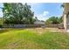 Large backyard with lush green grass, mature trees, and a privacy fence, perfect for outdoor activities at 5623 Wilde Oak Way, Sarasota, FL 34232