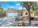 Charming one-story home featuring an attached garage, mature landscaping, and a welcoming front porch at 5623 Wilde Oak Way, Sarasota, FL 34232