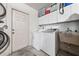 Functional laundry room with washer, dryer, utility sink, cabinets and access to the exterior at 5623 Wilde Oak Way, Sarasota, FL 34232