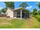 Enclosed screen patio includes a dining table and chairs and overlooks the grassy backyard at 5623 Wilde Oak Way, Sarasota, FL 34232